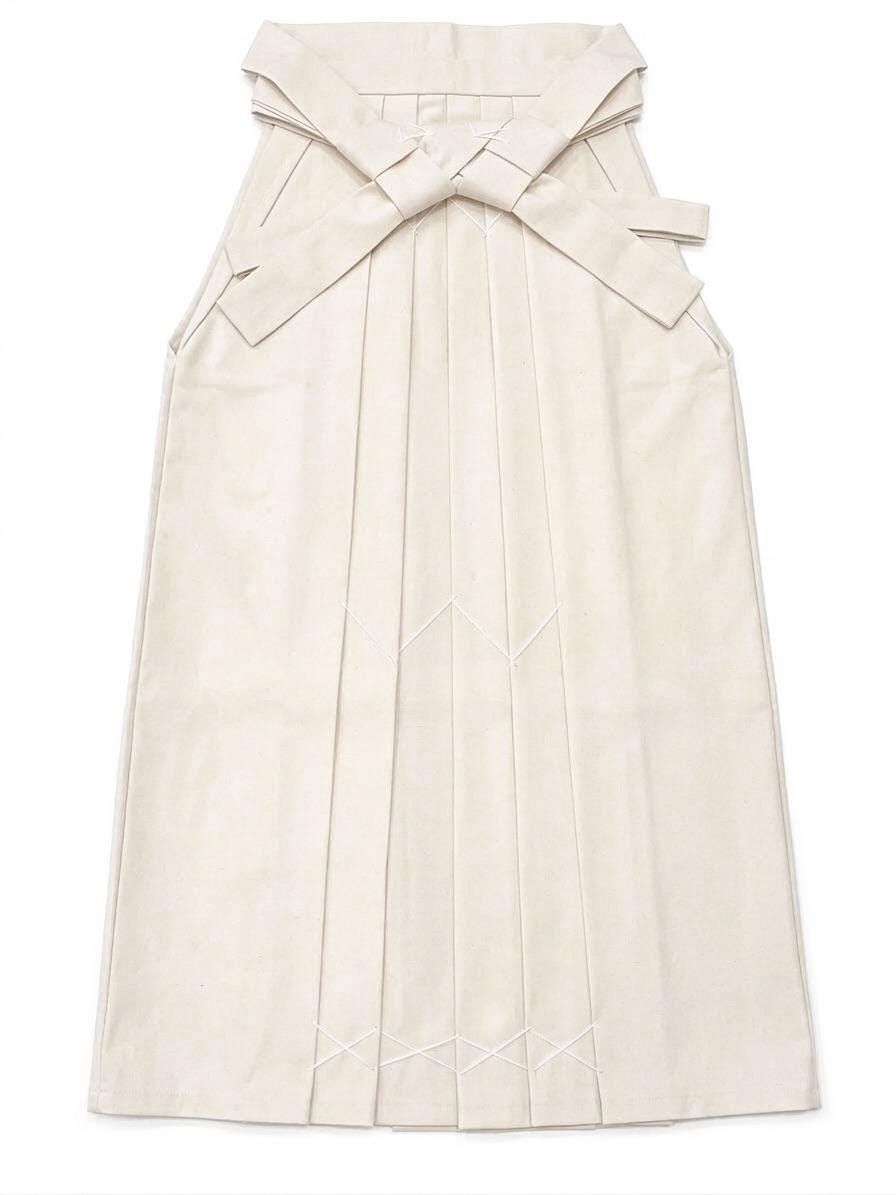 May include: Cream-colored hakama, a traditional Japanese garment, with a pleated design. The hakama features a large bow at the back and decorative stitching. The fabric appears to be a soft, matte material.