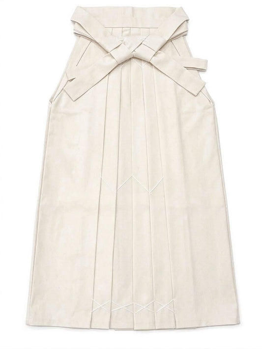 May include: Cream-colored hakama, a traditional Japanese garment, with a pleated design. The hakama features a large bow at the back and decorative stitching. The fabric appears to be a soft, matte material.