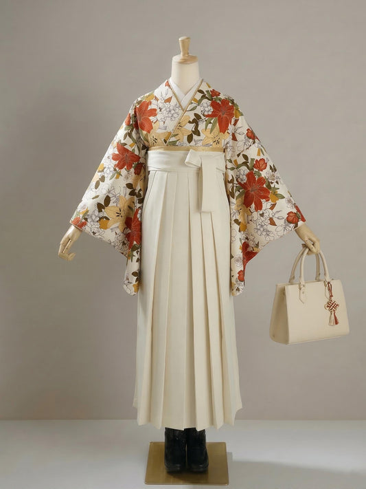 May include: A traditional Japanese hakama outfit displayed on a mannequin. The outfit includes a cream-colored pleated skirt, a floral kimono with red and yellow flowers, and a cream-colored handbag with a decorative charm.